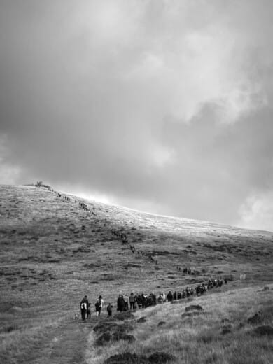 A line of people climb to the top of a fell in the Yorkshire Dales