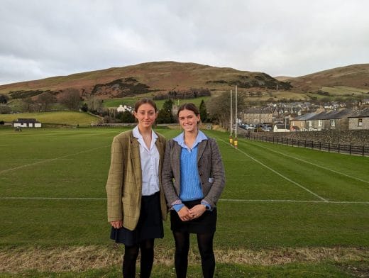 Elif & Isabelle stand in front of Powell Pitch, overlooked by Winder