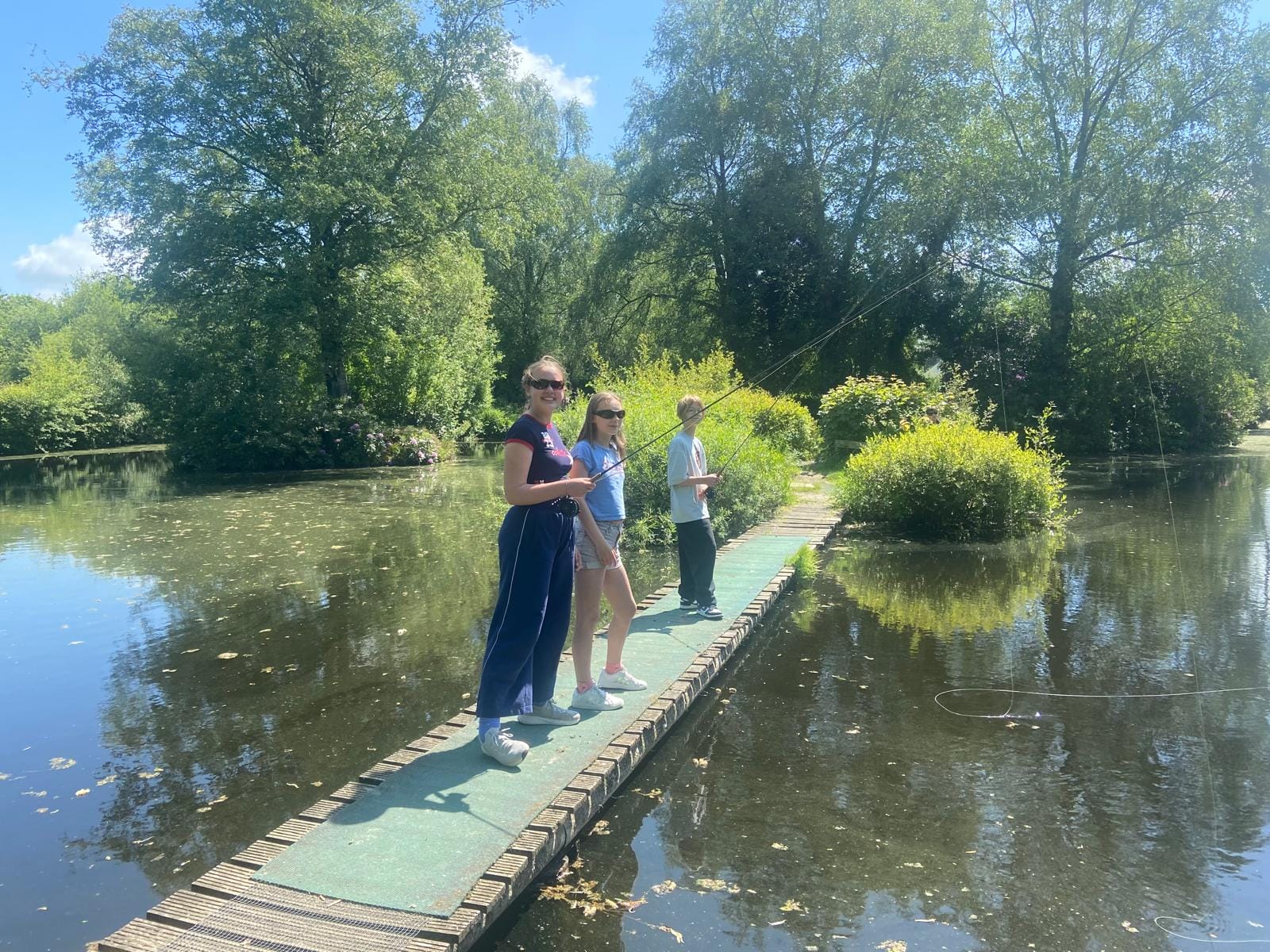 girls fishing by a pond